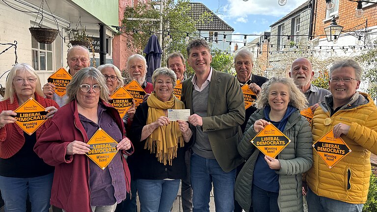 Bridport & Chesil Bank Candidates stood outside the Bull Hotel in Bridport with Edward Morello A group of Bridport & Chesil Bank Liberal Democrat Candidates and Councillors stood with Edward Morello stood outside the Bull Hotel holding 'Liberal Democrats Winning Here' window posters.