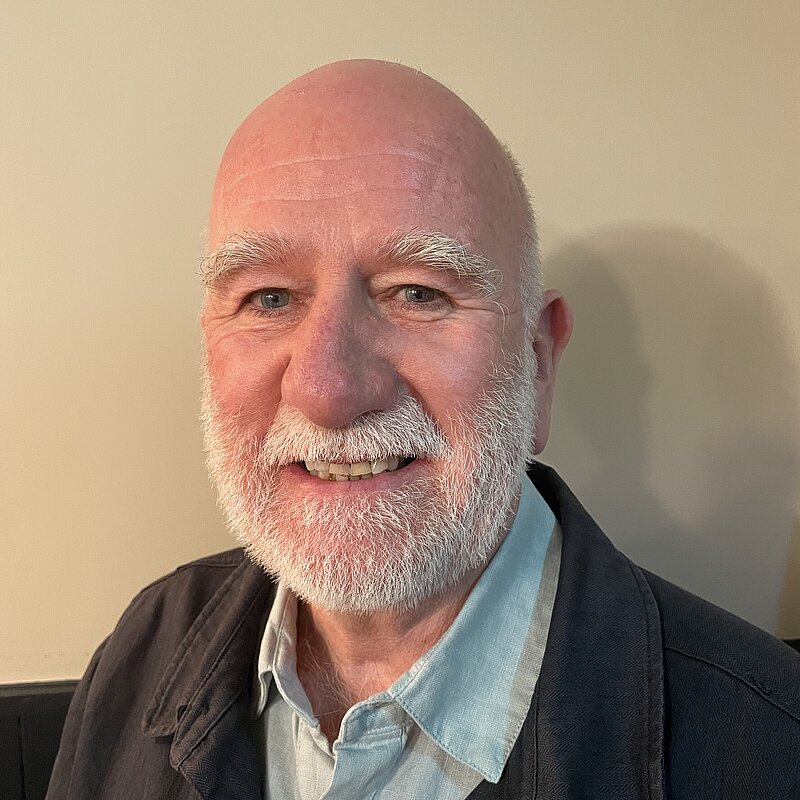 Ian Bark with a white beard, wearing a blue shirt