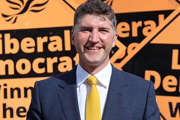 Edward Morello Stood in front of Liberal Democrat Stake Boards