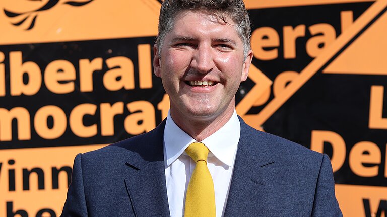 Edward Morello Stood in front of Liberal Democrat Stake Boards