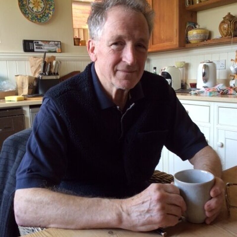 Guy Patterson wearing a navy polo shirt in his kitchen at his kitchen table