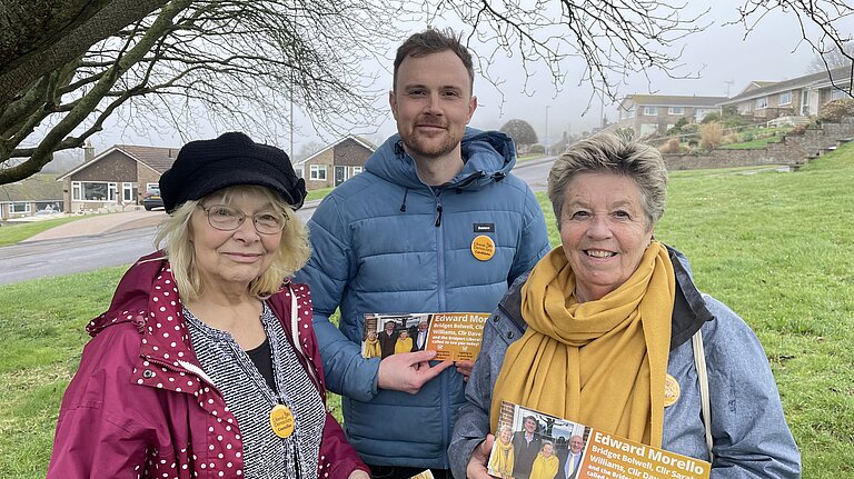 Anne Rickard, Andy Holdridge, and Bridget Bolwell Anne Rickard wearing a black and white top, and a pink jacket. She is stood with Andy Holdridge in a blue puffer jacket, and Birdget Bolwell wearing a yellow scarf andf blue jacket.