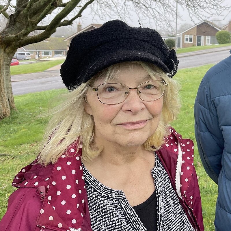 Anne Rickard, wearing a black beret, black and white top, and pink jacket. She is stood with Andy Holdridge, wearing a Blue puffer jacket.
