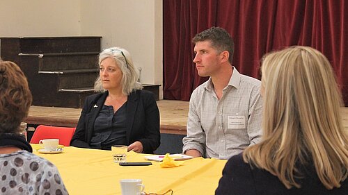 Edward Morello sat a table with 2 female presenting people talking