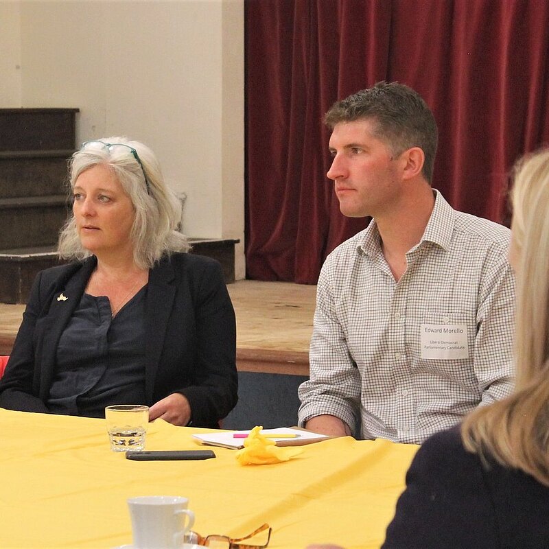 Edward Morello sat a table with 2 female presenting people talking