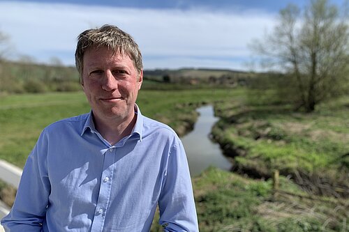 James on a sunny day with the Cuckmere river behind him.