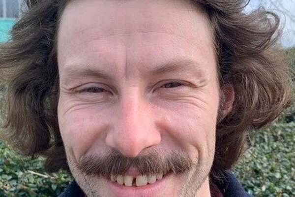 Rory Major with a moustache and wearing a red checked shirt and blue jacket